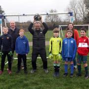 Some of the young footballers with Blair Dinwoodie, centre, who coached them during Covid-19 pandemic, and parents Frazer Robertson, left, and Claire Paterson, right, who are calling for the large goalposts to be reinstated at the park area etween