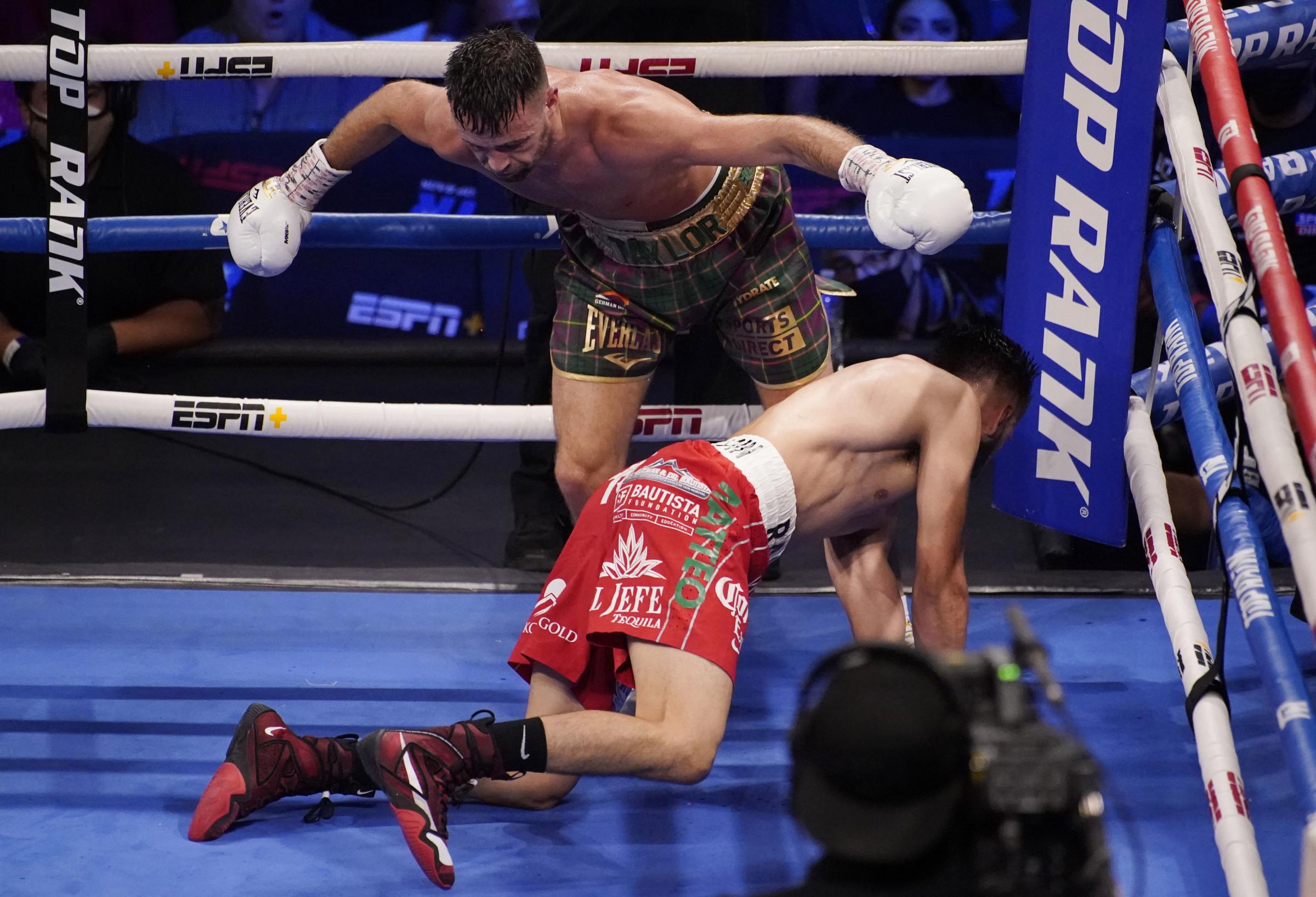 Josh Taylor knocks down Jose Ramirez during a junior welterweight title boxing bout Saturday, May 22, 2021, in Las Vegas. (AP Photo/John Locher).
