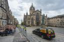 The hearse carrying the coffin of Queen Elizabeth II passes St Giles Cathedral as it travels along the Royal Mile in Edinburgh