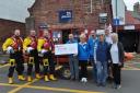 Dunbar Community Pétanque founder Stuart McCombie (centre), surrounded by club members, presents the cheque to RNLI representatives