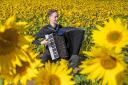 Accordionist Ryan Corbett, from Milngavie, plays in a field of sunflowers at Balgone, East Lothian, for the launch of the classical music Lammermuir Festival which took place earlier this month. Image: Jane Barlow/PA Wire.