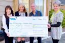 Irene Ferrie, singer Eddie Raven and organiser Carol Edmond, from the Musselburgh Over 50's Club, present a cheque for £1,000 to Laura Munro, a volunteer at St Columba's Hospice