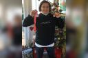 Julie LaRoche holds her Reindeer Run Challenge Medal alongside her father's RNLI 50-year award