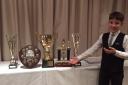 Adon Davie shows off his awards