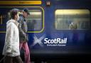 People walking beside a Scotrail train. Credit: PA