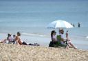 People sunbathing on the beach. Credit: PA