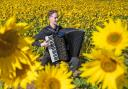 Accordionist Ryan Corbett playing in a field of sunflowers at Balgone for the launch of last year’s Lammermuir Festival. Image: Jane Barlow/PA Wire