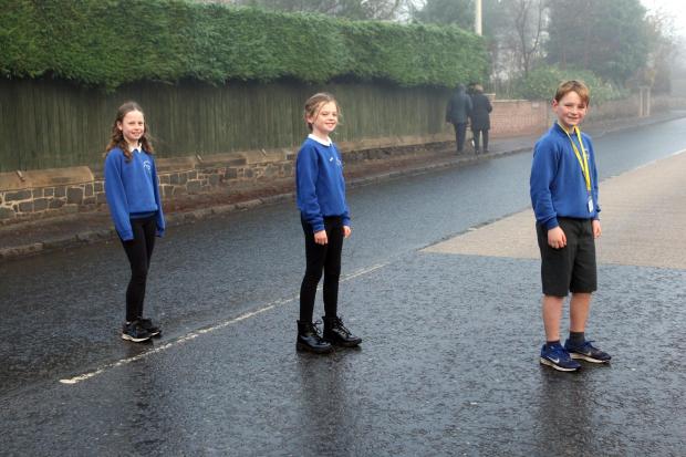 Gullane Primary School junior road safety officers Ella Wilson, Hannah Carter and Josh Spink safely crossing the main road in the village, with the help of some adults (not in shot)