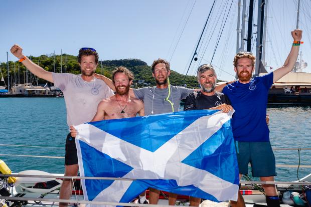 East Lothian Courier: The team (from l-r): Duncan, Fraser, Ian, Ross and Clive) unfurl the Saltire to celebrate the end of their incredible journey. Image: Atlantic Campaigns