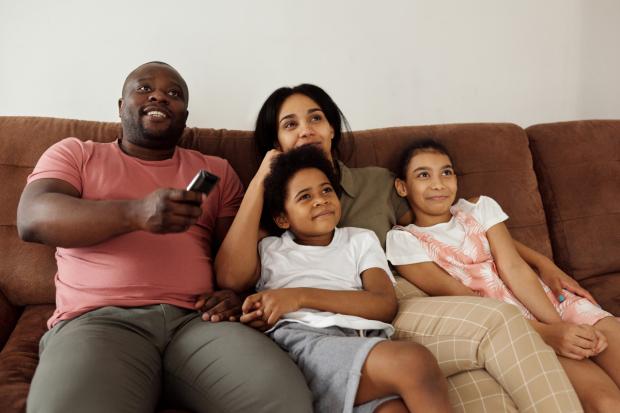 East Lothian Courier: A family watching TV together. Credit: Canva