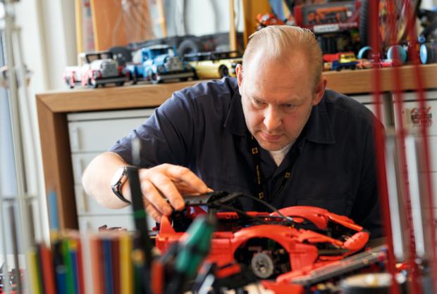 East Lothian Courier: A man assembling the LEGO Technic Ferrari Daytona SP3. Credit: LEGO