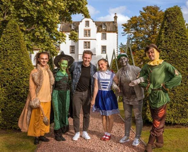 East Lothian Courier: Musselburgh singer-songwriter Callum Beattie enjoys a trip to the Land of Oz to meet the cowardly lion, wicked witch, Dorothy, the tin man and scarecrow, and help raise funds for CHAS