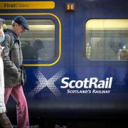People walking beside a Scotrail train. Credit: PA