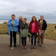 Left to right: Caroline Moors, Pauline Fairly, Chloe Downey, group leader Shona Black and Caroline McKenzie on one of the fortnightly walks. In the background, enjoying a run around together, are assistance dog Waffle, a yellow labrador, and guide dog