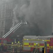 Smoke billows from the front of the building yesterday