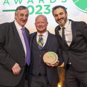 Chris Logan (centre) was presented the award by farmer Meurig Raymond, MBE (left), and comedian Patrick Monahan (right). Image: Lewis Business Media and Farm Contractor