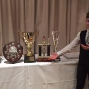 Adon Davie shows off his awards